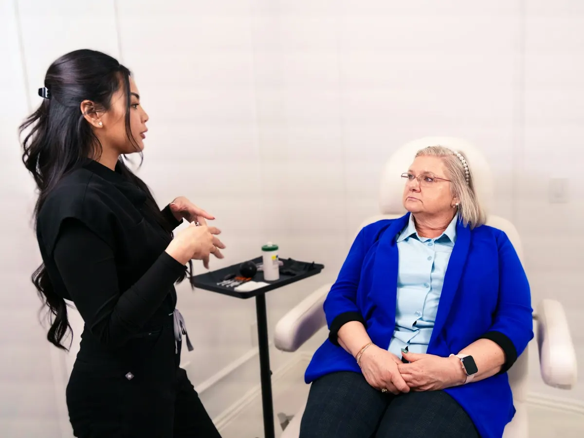 Fisioterapeuta conversando com uma paciente idosa durante a avaliação